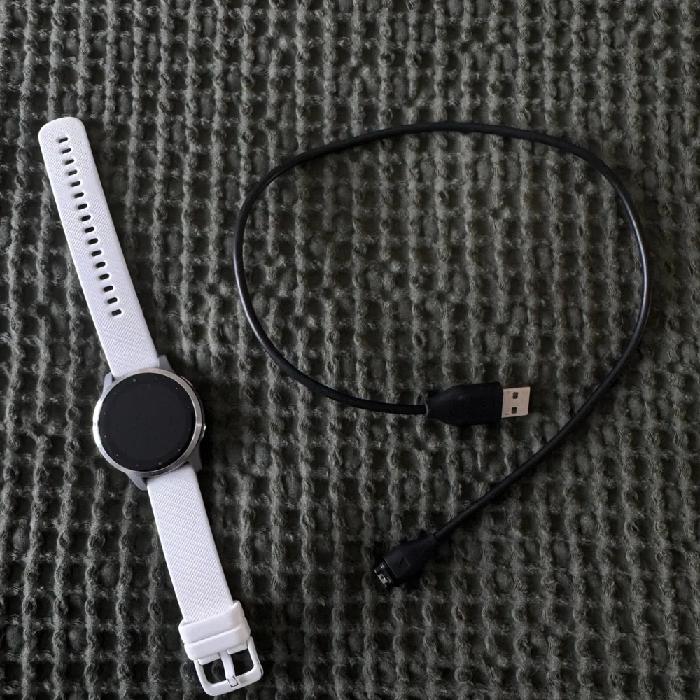 garmin vivoactive 4s white smartwatch with black charger cable